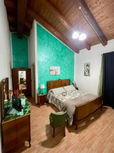 a bedroom with a bed and a green wall at B & B La Ca' Di Massuc in Peveragno