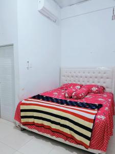 a bed with an american flag blanket on it at Kost harian bu bunga in Lambaro