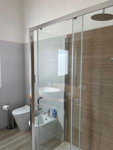 a bathroom with a glass shower and a sink at Calasetta casa al mare in Calasetta +42 photos