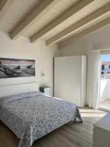 a bedroom with a bed and a large window at Calasetta casa al mare in Calasetta