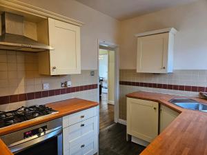 a kitchen with white cabinets and a stove top oven at Sand-Ring-Ham in Moortown