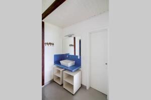 uma casa de banho com um lavatório azul num quarto branco em Sol-lua Bangalo com uso exclusivo da piscina em Ilhabela