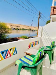a patio with a table and chairs and a river at Dangy Kato in Aswan +21 photos