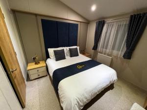 a bedroom with a bed and a large window at Meadows 33 Hot tub - Southview Holiday Park in Skegness