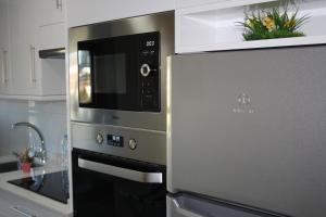 a kitchen with a stainless steel oven and a microwave at Apartamento A Cabana II in Porriño
