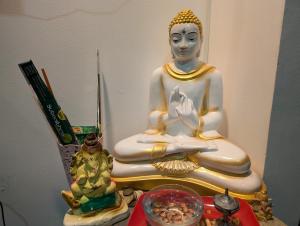 a statue of a buddha sitting on a table at Costels Mirissa in Mirissa