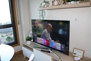 a flat screen tv sitting on a stand in a living room at Apartamento A Cabana II in Porriño