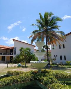 a large white fountain in front of a building with a palm tree at Delta Park Hotel in Parnaíba