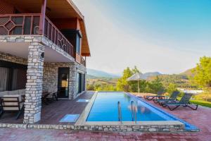 a swimming pool in front of a house at Adrasan Villa Adrasya in Olympos