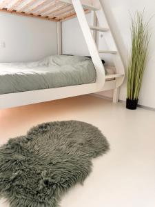 オーステンデにあるLuxe d’Oの二段ベッドと毛皮の敷物が置かれた寝室