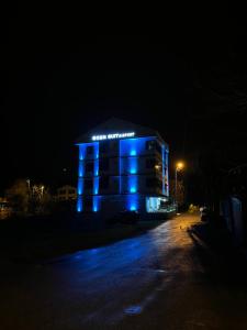 a building with blue lights on it at night at Ozn Suit Airport Hotel in Arnavutköy