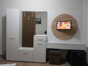 een kamer met een bureau en een tv aan de muur bij Pensiunea White House in Straja +32 foto's