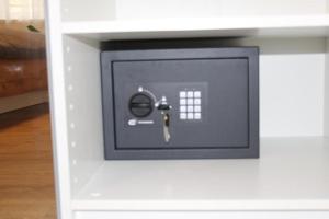 einen Safe in einem weißen Schrank mit einem Schlüssel. in der Unterkunft Appartement rénové place du Palais avec parking in Bordeaux
