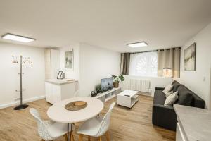 ein Wohnzimmer mit Tisch und Stühlen und einer Couch in der Unterkunft Appartement rénové place du Palais avec parking in Bordeaux