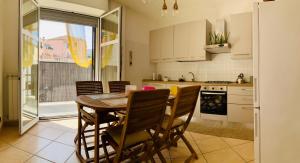 a kitchen with a dining room table and chairs at Casa di Emma in Vado Ligure