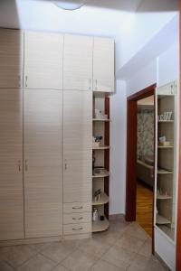 a dressing room with white cabinets and a mirror at Iva Lux stan na dan in Banja Luka