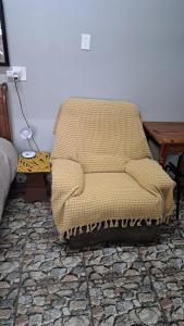 una silla sentada en la esquina de una habitación en At Home Guest House, en Postmasburg