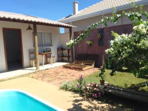 een achtertuin met een zwembad en een huis bij Pousada Canto das Estrelas in Chapada dos Guimarães
