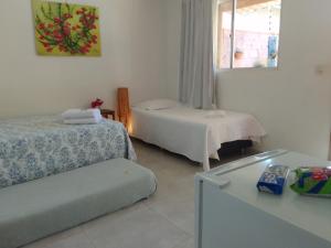 a hotel room with two beds and a window at Pousada Canto das Estrelas in Chapada dos Guimarães