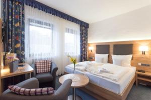 une chambre d'hôtel avec un lit, une table et des chaises dans l'établissement Hotel Garni "Zur Alten Post", à Willingen
