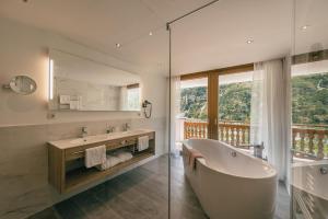 duża łazienka z wanną i oknem w obiekcie Gourmet & Wine Hotel Austria - 4 Sterne superior w mieście Obergurgl