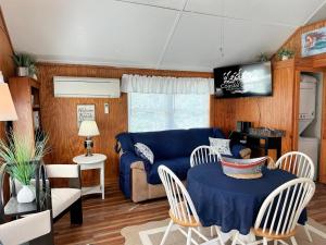 Una sala de estar con un sofá azul y una mesa. en NH339B Beach Angel, en Nags Head