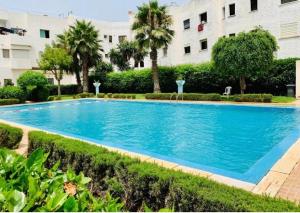 a large blue swimming pool in front of a building at Bella Harhoura in El Harhoura