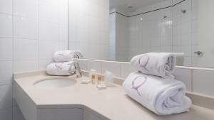 a bathroom with towels on a sink and a mirror at Hôtel Ours Blanc - Centre in Toulouse +13 photos