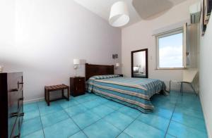 una camera con letto e pavimenti piastrellati blu di Cortile San Giovanni a Mazara del Vallo