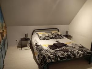 a bedroom with a bed with a black and white comforter at Cottage champêtre in Marmoutier