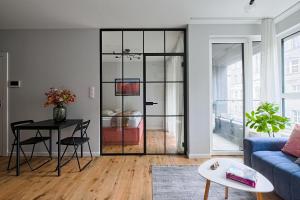salon z niebieską kanapą i stołem w obiekcie UrbanNestapartments-Op51 w mieście Katowice