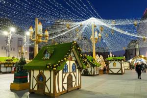 a group of gingerbread houses on a street with lights at Apartament City Center Craiova in Craiova