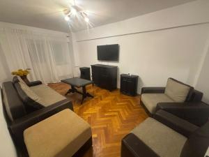 a living room with two couches and a flat screen tv at Apartament City Center Craiova in Craiova