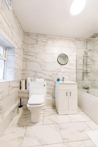 a bathroom with a toilet and a tub and a sink at 3Bed Cottage - WiFi & Parking - Perfect for Contractors in Sunderland +124 photos