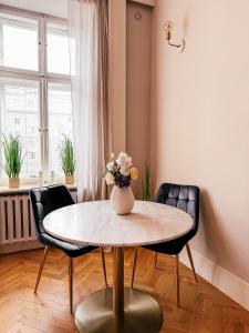 a dining room table with a vase of flowers on it at Old Town Heart XVIII - Downtown Luxury in Warsaw