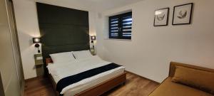 a small bedroom with a bed and a couch at Tarnów Velo Apartament - Dom in Tarnów