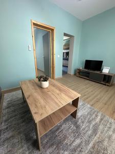 a living room with a wooden coffee table and a tv at Christina Apartment in Drama