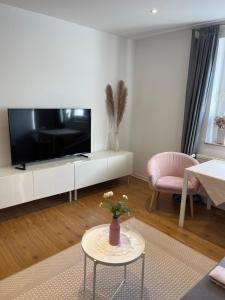 a living room with a flat screen tv and a table at Groß, aber gemütlich - citynah in Unna