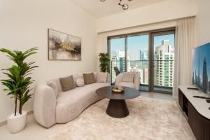 een woonkamer met een bank en een tafel bij Prime Retreats @ Burj Royale By Emaar in Dubai
