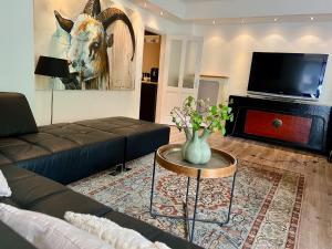 a living room with a couch and a table and a television at De Biejebosj in Valkenburg