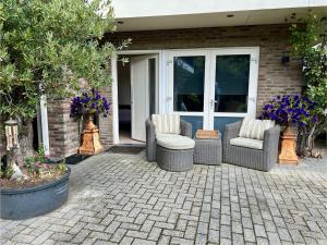 a patio with two chairs and a table at De Biejebosj in Valkenburg