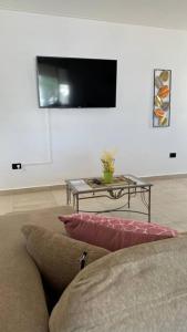 a living room with a couch and a table with a tv at 2A Estepa Apart-centro costanera in Comodoro Rivadavia