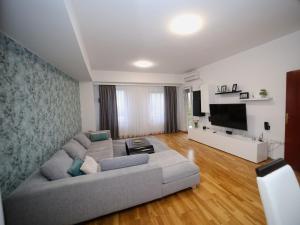 a living room with a couch and a flat screen tv at Iva Lux stan na dan in Banja Luka