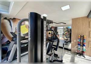 a gym with tread machines and skis in a room at Apto próximo a praia em Riviera in Bertioga