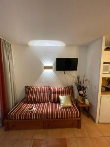 a couch sitting in a living room with a tv at Séjour 4 personnes - Pays Basque in Uhart-Cize +2 photos