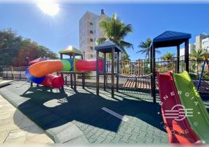 a playground with a slide in a park at Apto próximo a praia em Riviera in Bertioga