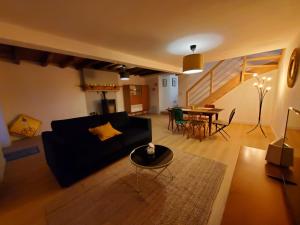 a living room with a black couch and a table at Les palis de Sert in La Chapelle-de-Brain