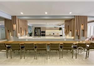 a kitchen and dining room with a long table and chairs at Apto próximo a praia em Riviera in Bertioga