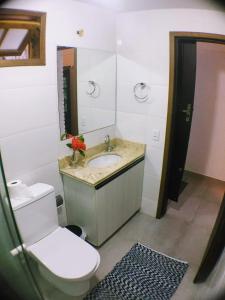 a bathroom with a sink and a toilet and a mirror at LOFT Privado próx Garten Shopping-Universidades in Joinville