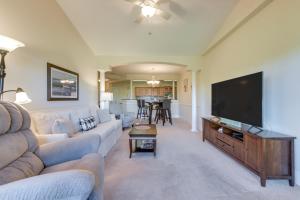a living room with a couch and a flat screen tv at 3 Mi to Beach - Edgewater at Barefoot Resort Condo in Myrtle Beach